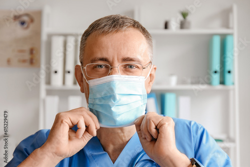 Mature male doctor putting ...