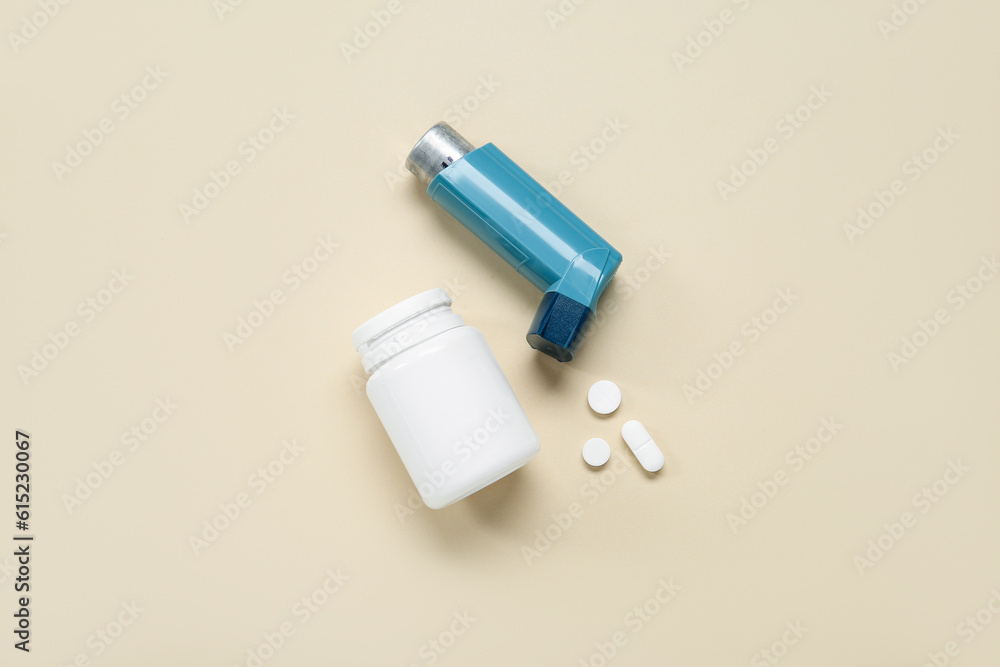Asthma inhaler and box with pills on beige background Asthma inhaler and box with pills on beige background