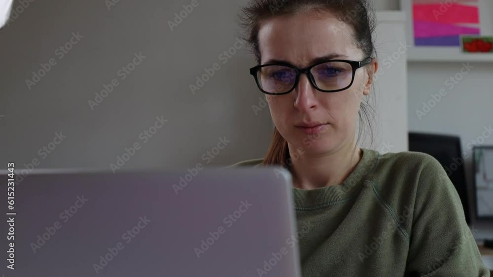 Young woman focused on laptop while sitting at table Young woman focused on laptop while sitting at table