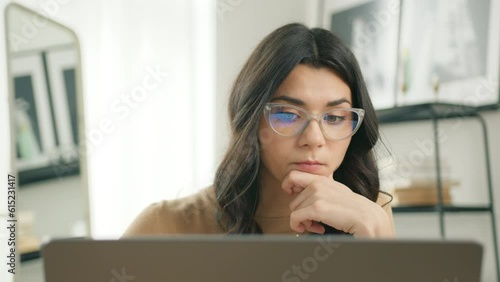 Education people slow. Smart hispanic freelancer woman in eyeglasses working on computer at home. Casual concentrated latin female entrepreneur developing new project while working on laptop at home
