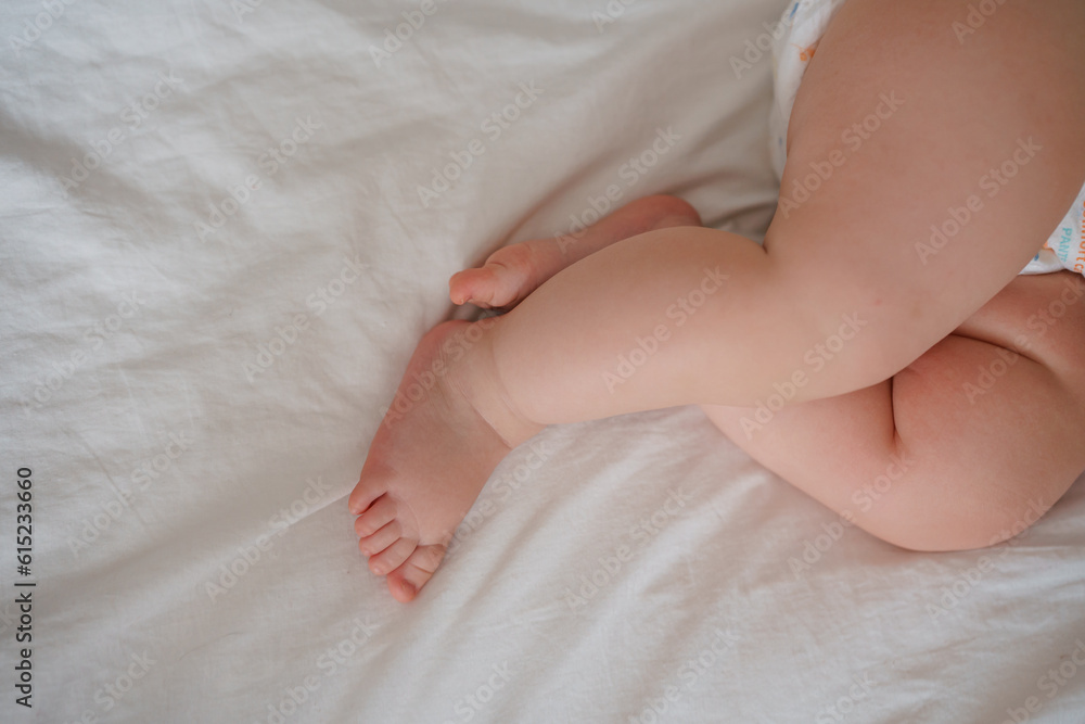 The legs of the baby's foot on a white sheet