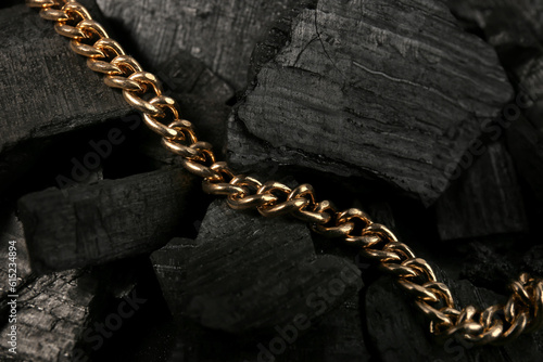 Beautiful chain necklace on black charcoal, closeup
