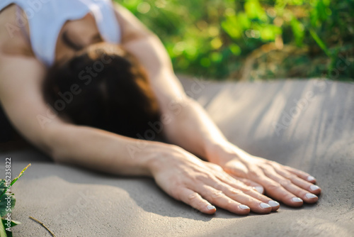 Attractive woman practicing yoga, relaxing after training, lying face down