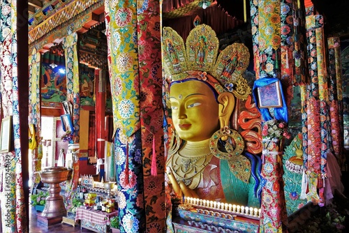 Discover the grandeur of Thiksey monastery in Indian Ladakh, featuring a colossal two-story high Buddha statue adorned with vibrant decorations, exuding tranquility and cultural richness.