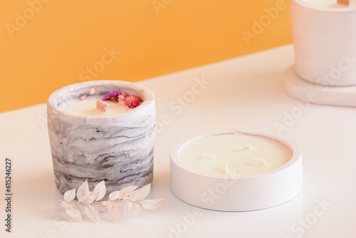 Holders with candles on table near orange wall in room  closeup