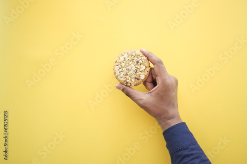 overhead view of holding sweet cookies on yellow background 