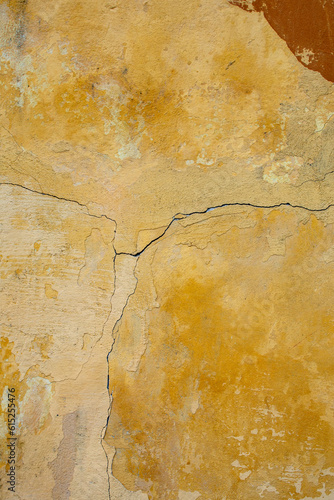Closeup of a cracked vintage wall in yellow