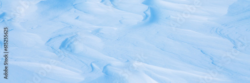 Beautiful winter background with snowy ground. Natural snow texture. Wind sculpted patterns on snow surface. Arctic, Polar region. © Andrei Stepanov