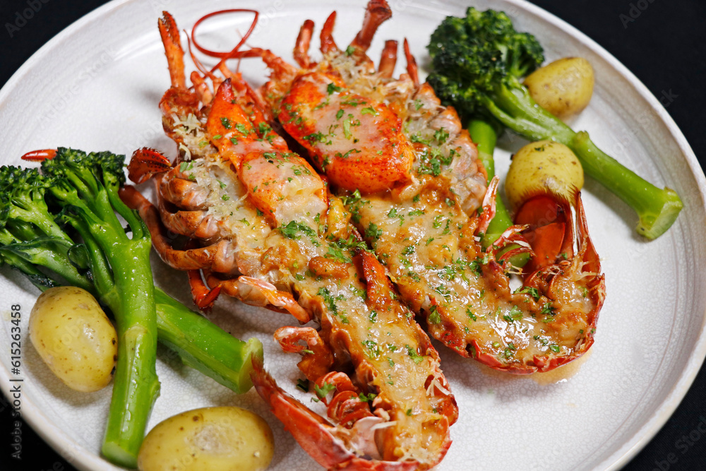 canadian maine lobster thermidor dish with broccoli and baby potato, black background canadian maine lobster thermidor dish with broccoli and baby potato, black background