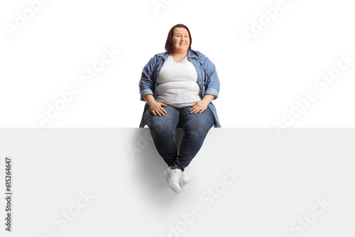 Bild auf Leinwand Young overweight woman sitting on a blank panel