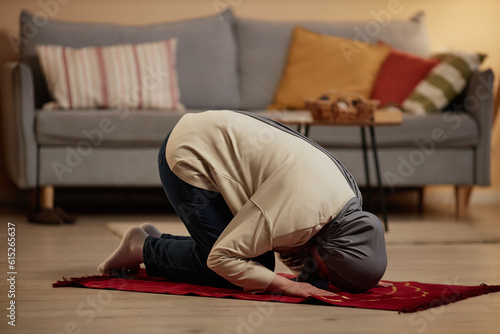 Foto Young Muslim woman in grey hijab and casualwear bending forwards while standing
