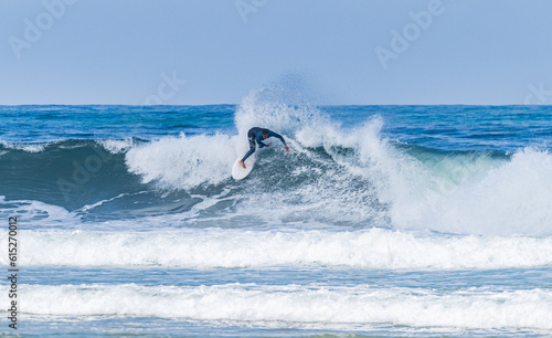 Young athletic surfer rides the wave