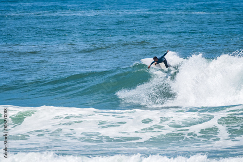 Young athletic surfer rides the wave