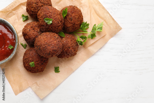 Vegan meat products. Delicious falafel balls, parsley and sauce on white table, flat lay. Space for text