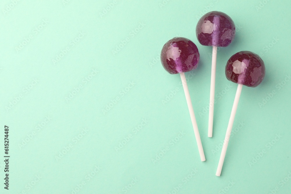 Tasty lollipops on turquoise background, flat lay. Space for text Tasty lollipops on turquoise background, flat lay. Space for text