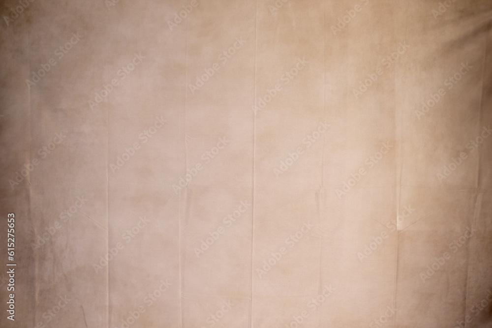 Fototapeta premium Hanging fabric with beige texture and vignette. Cloth photography background. texture for portraits