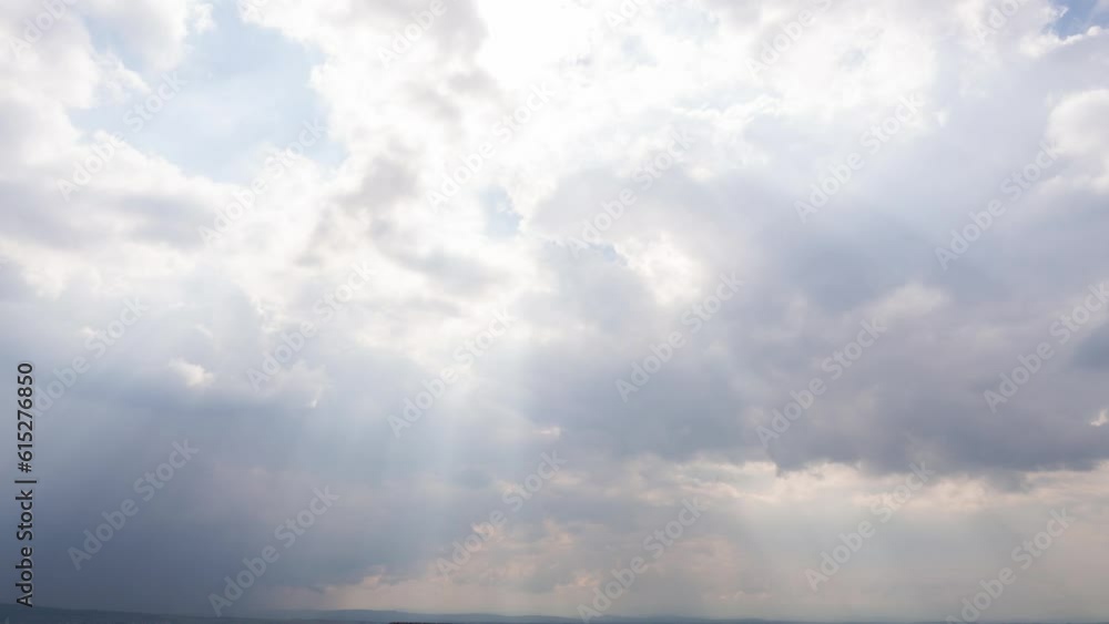 sunbeam through fluffy soft pastel blue clouds on a sunny day. sunlight shines from heaven's beautiful atmosphere. lookup view to the air in blue sky scenery. time-lapse cloudscape sun rays landscape sunbeam through fluffy soft pastel blue clouds on a sunny day. sunlight shines from heaven's beautiful atmosphere. lookup view to the air in blue sky scenery. time-lapse cloudscape sun rays landscape