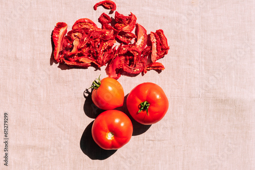 Fresh and dried tomatoes lie on the kitchen table, top view. Harvesting and processing of vegetables, vegetarianism photo