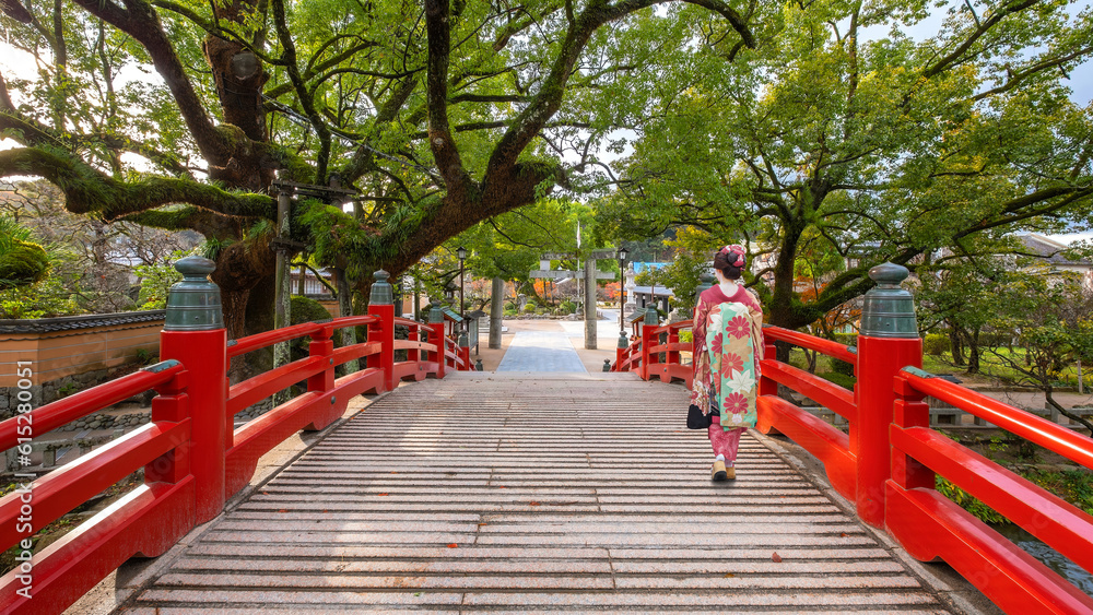 A Japanese Geisha in Traditional Kimono Costume cross the Bridge at Dazaifu Tenmangu Shrine in Fukuoka A Japanese Geisha in Traditional Kimono Costume cross the Bridge at Dazaifu Tenmangu Shrine in Fukuoka