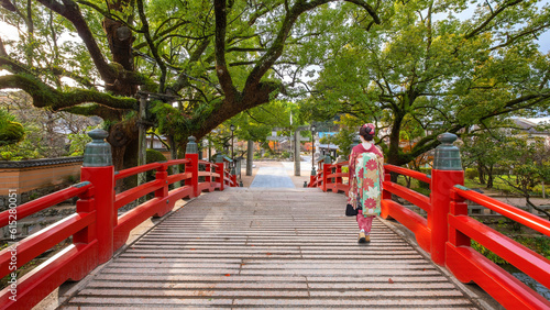 A Japanese Geisha in Traditional Kimono Costume cross the Bridge at Dazaifu Tenmangu Shrine in Fukuoka