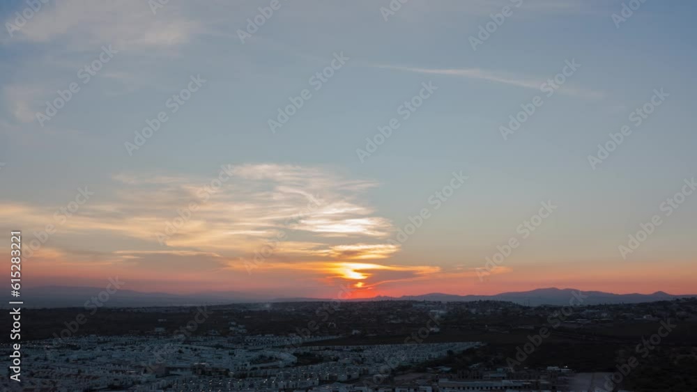 Sunset drone shot hyper-lapse above Queretaro's new neighborhood. Burning sun between the clouds and the mountains. Sunset drone shot hyper-lapse above Queretaro's new neighborhood. Burning sun between the clouds and the mountains.
