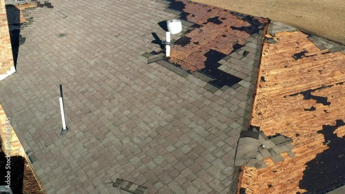 Tornado damage to roof with missing shingles, in need of repair
