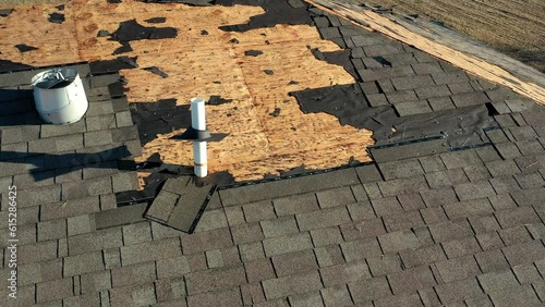 Tornado damage to roof with missing shingles, in need of repair