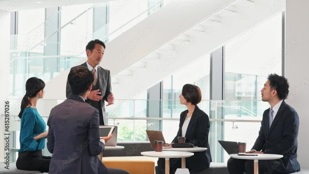 Group of various generation Asian businesspeople meeting in lobby. Office workers discussing for success. Group of various generation Asian businesspeople meeting in lobby. Office workers discussing for success.