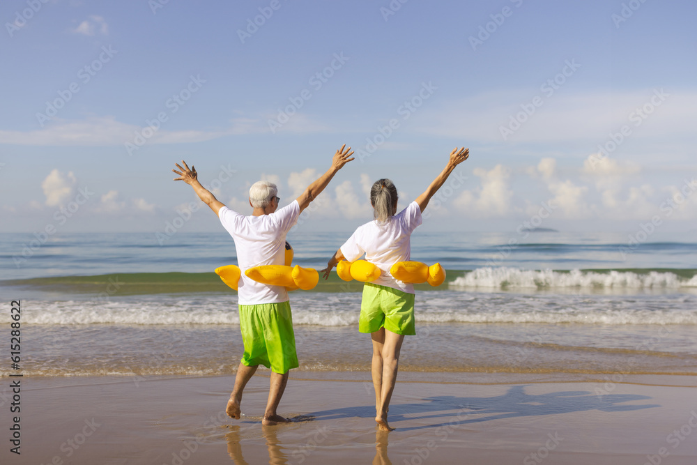 Retired couple happily running on the beach. Plan life insurance and retirement concept.