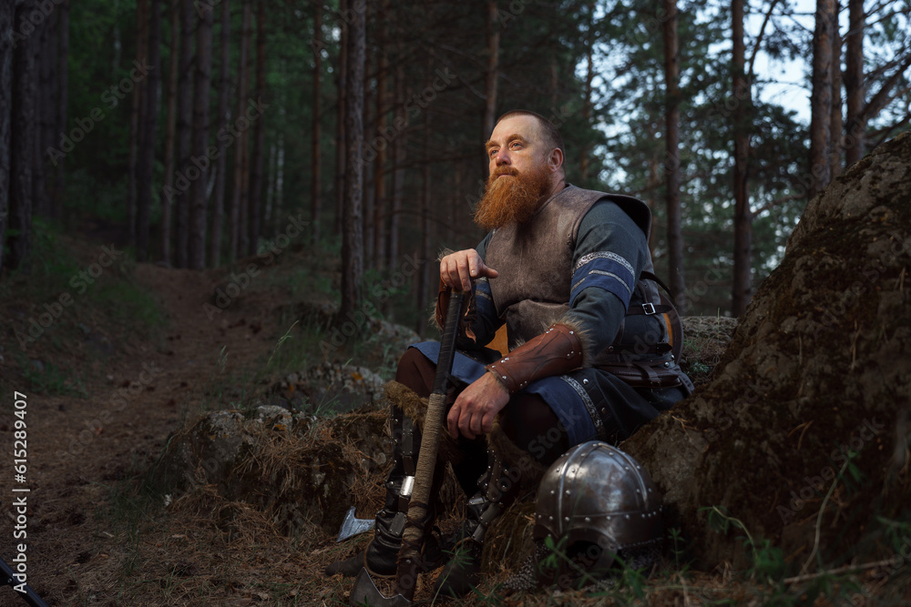 Medieval warrior viking barbarian with ax and shield in forest Medieval warrior viking barbarian with ax and shield in forest