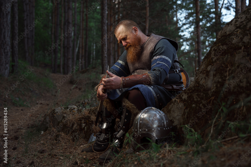 Medieval warrior viking barbarian with ax and shield in forest Medieval warrior viking barbarian with ax and shield in forest