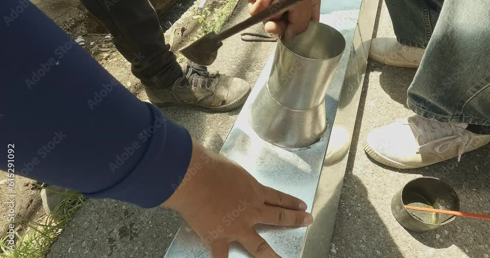Zinc rain gutter welding by using soldering copper. Technician is