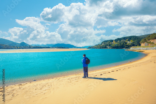 A tourist stands on the beach. Laida beach, Urdaibai biosphere reserve, Basque Country, Spain photo