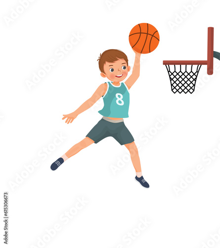 Cute little boy basketball player jumping high performing slam dunk in action