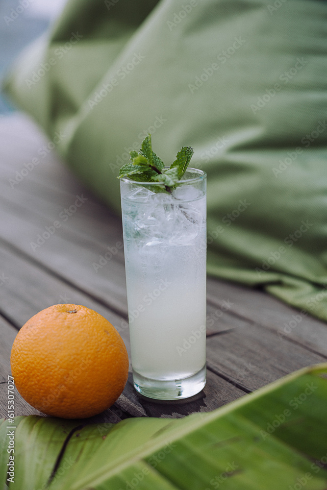Mojito cocktail or mocktail with lime, mint, and ice in glass on blue background. Summer cold alcoholic non-alcoholic drink, beverage and cocktail. Tropical or summer drinks concept Mojito cocktail or mocktail with lime, mint, and ice in glass on blue background. Summer cold alcoholic non-alcoholic drink, beverage and cocktail. Tropical or summer drinks concept
