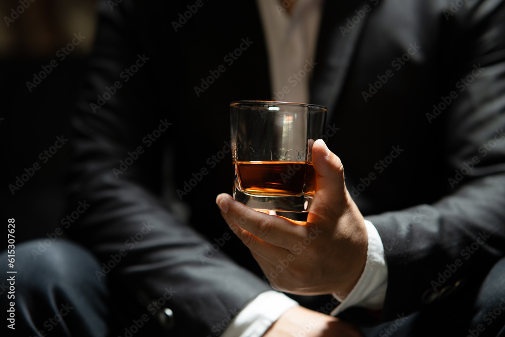 Businessman sitting Holding a Glass of Whiskey Drink Whiskey in the liquor store room Businessman sitting Holding a Glass of Whiskey Drink Whiskey in the liquor store room