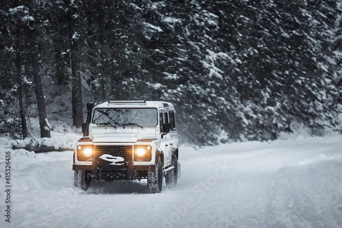 Vintage SUV Conquering the Winter Forest in a Snowstorm. Vintage sport utility vehicle driving during snow storm in forest © AlexGo