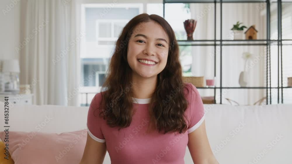 Front view webcam of asia people young gen z teen girl brown curly hair eye face toothy smile joy looking at camera sitting easy at home sofa. Happy new house enjoy relax simple living life balance. Front view webcam of asia people young gen z teen girl brown curly hair eye face toothy smile joy looking at camera sitting easy at home sofa. Happy new house enjoy relax simple living life balance.