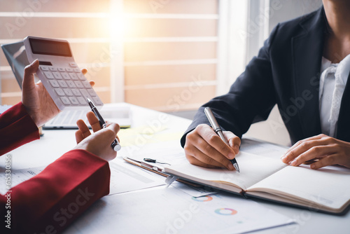 Close up hand young businesswoman calculating  working on desk office with the chart graph financial account