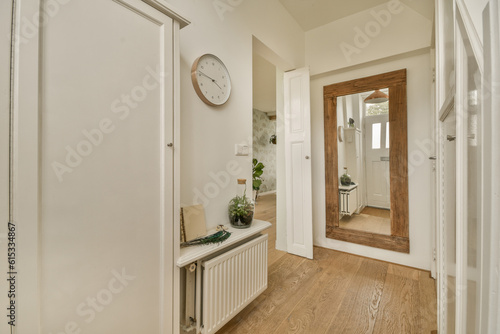 a hallway with wood flooring and a clock hanging on the wall above the door to the entranceway area