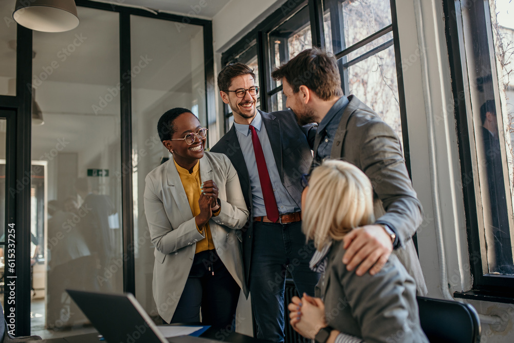 Group of a successful business people around a laptop celebrating good news. Group of a successful business people around a laptop celebrating good news.