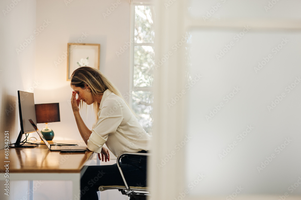 © Jacob Lund - Businesswoman feeling overwhelmed in her office