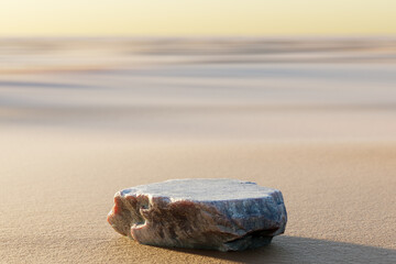 Granite Stone on beige beach sand texture. Display with sunshade and shadow on the background for cosmetic perfume fashion natural product