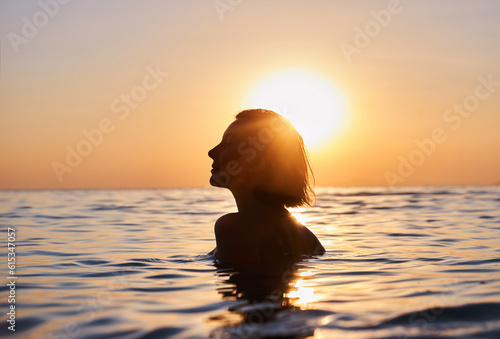 silhouette of woman relaxing in water at sunset, in the style of emotional sensitivity, serene faces, backlight, joyful and optimistic