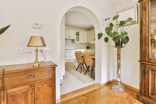 Fotografija a living room with a dining table and an archway leading to the kitchen in the d