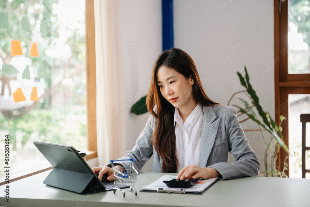 Young attractive Asian female office worker business suits smiling on desk in home office Young attractive Asian female office worker business suits smiling on desk in home office
