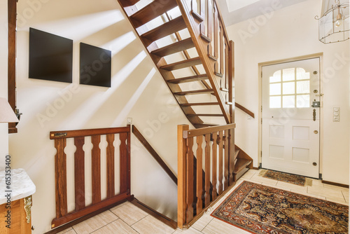 a stairway way in a house with wood railing and handrails on either side  leading up to the front door