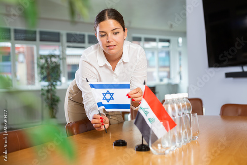 Quadro em tela Assistant girl prepares office for international negotiations and meetings of leaders