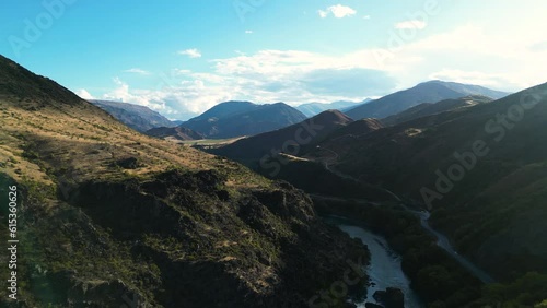 Aerial view over kawarau river surrounded by mountains during sunny day - connecting queenstown and cromwell in New Zealand photo