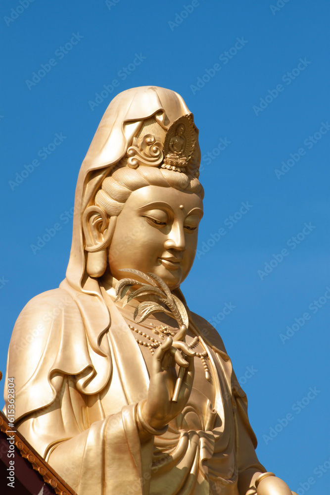 Statue of Guan Yin against blue sky